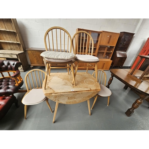 150 - An Ercol drop leaf dining table and three chairs