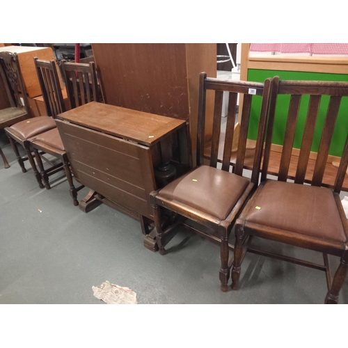 380 - An oak drop leaf dining table and four chairs