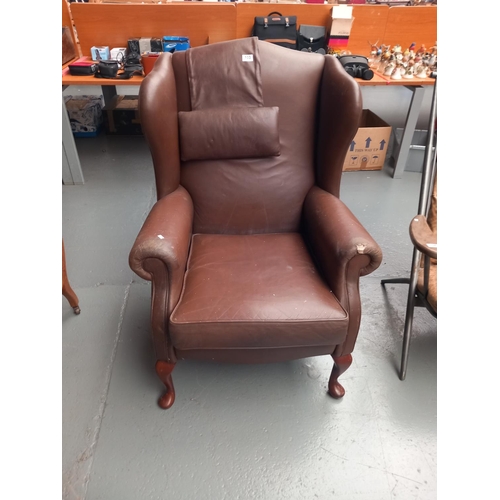 103 - A brown leather wingback armchair