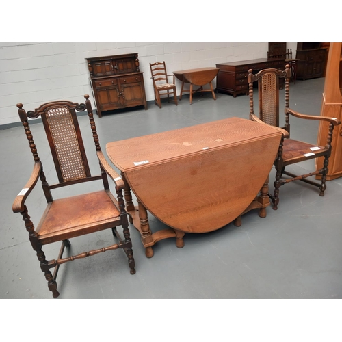 116 - An oak drop leaf dining table together with two oak frame chairs