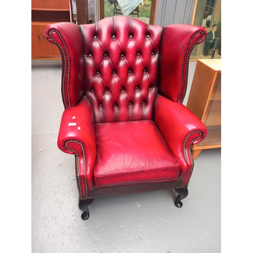 124 - A red leather chesterfield wingback armchair