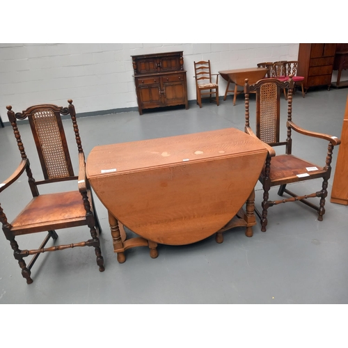 112 - An oak drop leaf dining table together with two oak frame chairs