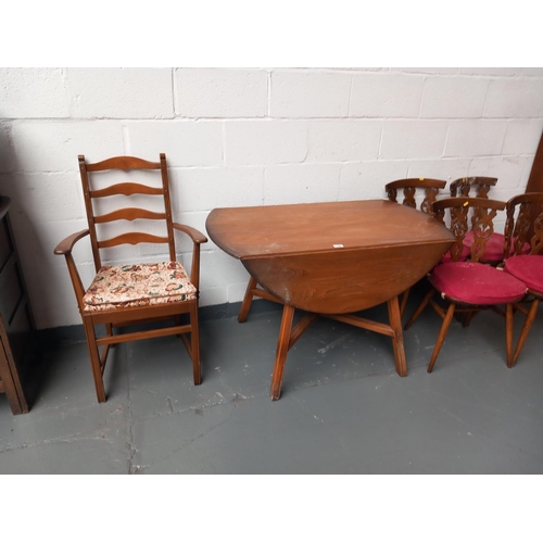 134 - An Ercol drop leaf dining table, four ercol fleur de lys dining chairs and one ercol armchair