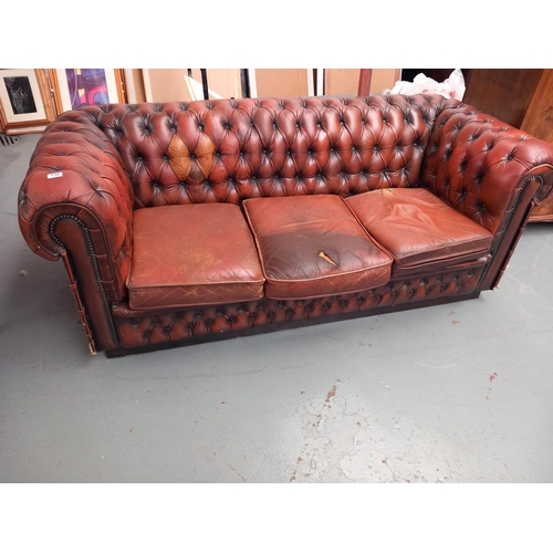 138 - A brown leather 3 seater Chesterfield sofa (rip to one cushion)