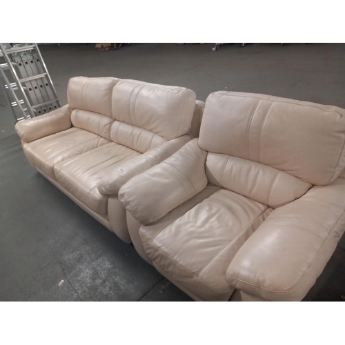 584 - A cream leatherette two seater sofa and armchair