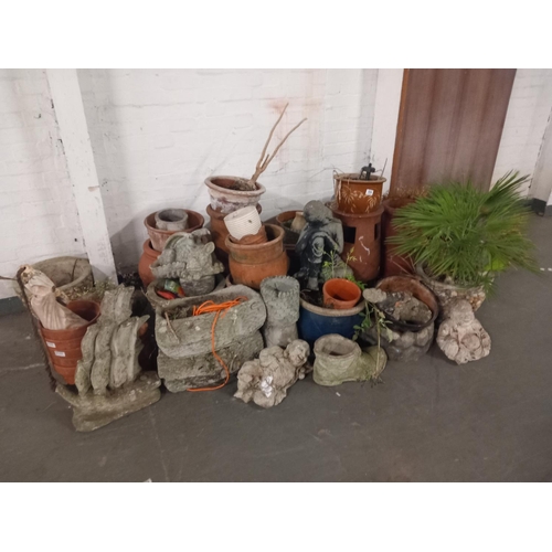 594 - A collection of stone and terracotta planters, ornaments etc