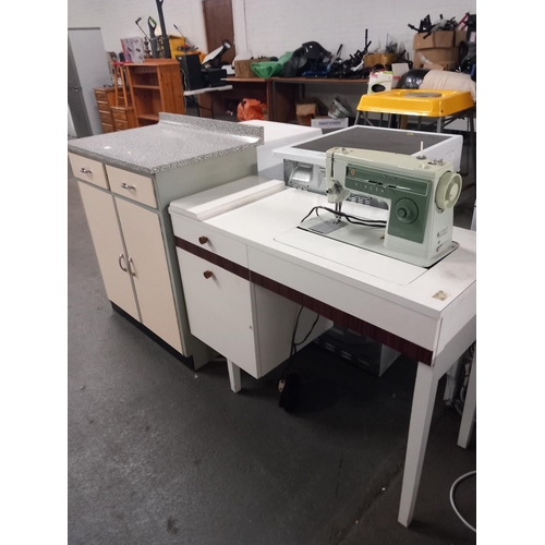 569 - A formica top kitchen cabinet and a retro sewing machine with cabinet