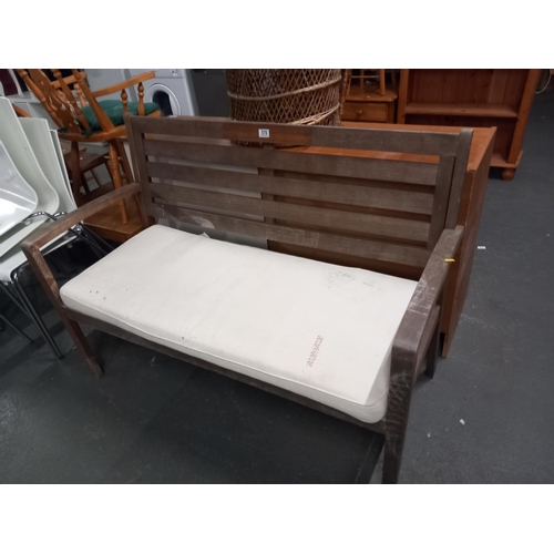 570 - A wooden garden bench with padded cushion