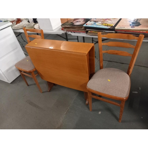 589 - A teak drop leaf dining table and two chairs