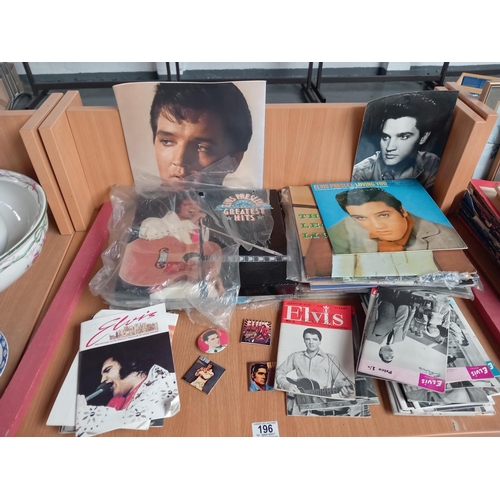 196 - A selection of Elvis memorabilia to include vinyl records, pin badges and Elvis Monthly magazines