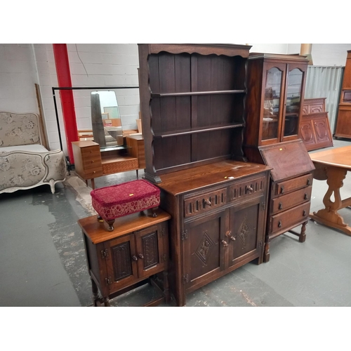 317 - An oak bureau bookcase, an oak dresser together with a small footstool and an oak cabinet