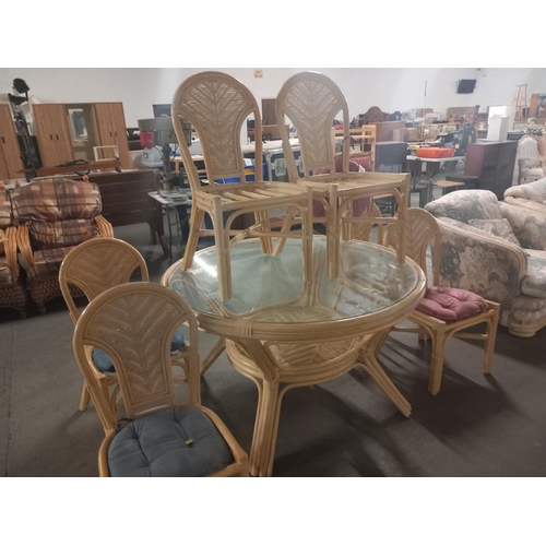 634 - A large circular glass topped bamboo dining table with six chairs