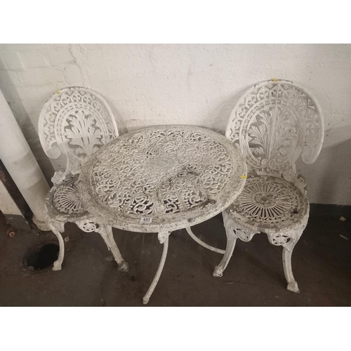 651 - A circular cast iron garden table and two chairs