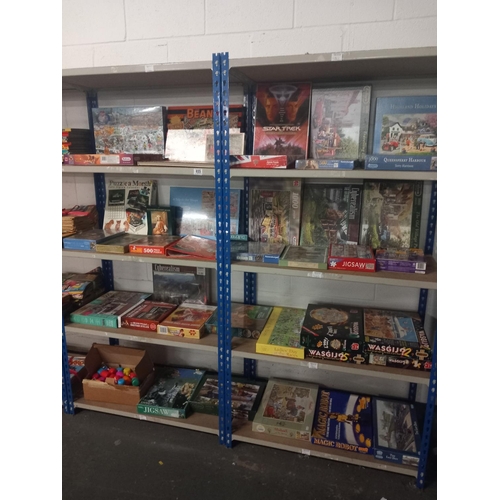 655 - Eight shelves of jigsaw puzzles and games