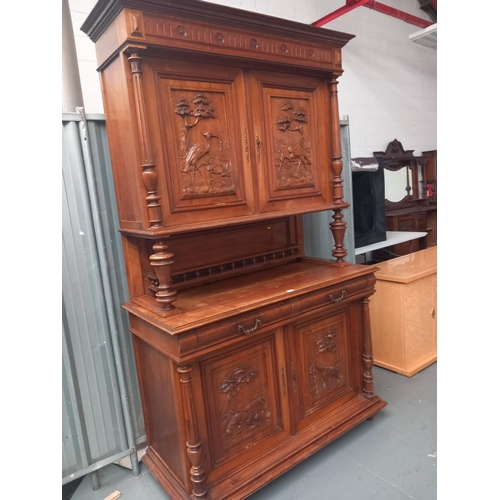 334 - A large continental oak dresser with carved panel doors