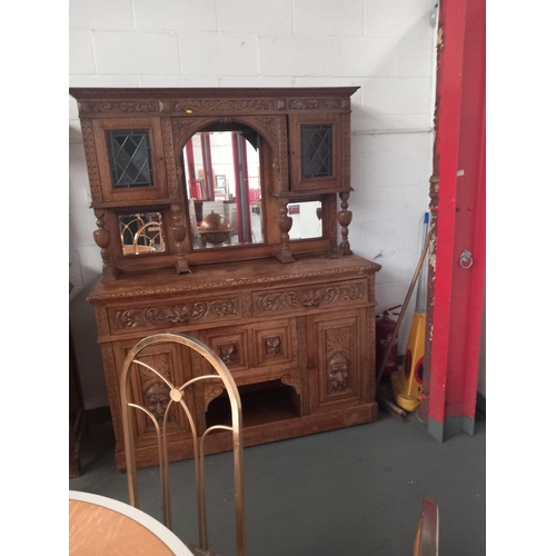 338 - An oak mirrored back dresser with carved panel doors and stained glass windows