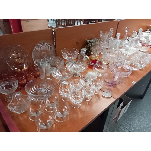 67 - A quantity of crystal, pressed and coloured glass - decanters, vases, bowls etc