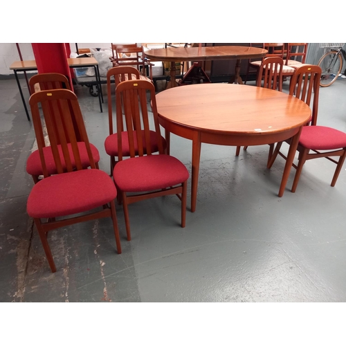 122 - A circular teak extending dining table and six chairs