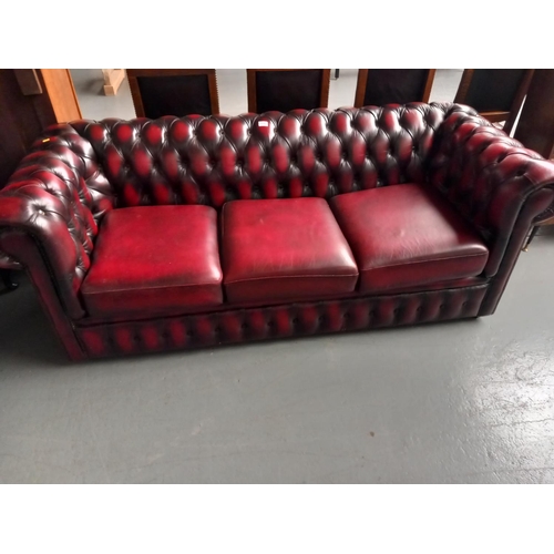 132 - A red leather Chesterfield three seater sofa