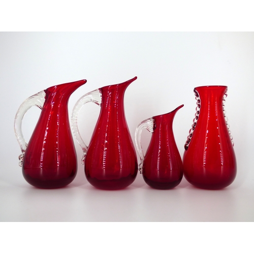 93 - Whitefriars, assorted ruby red jugs, vases, Dilly Duck and small tankard.

Heights 12.5 to 20cm.