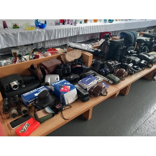 118 - A collection of Olympus, Polaroid, and Pentax cameras, binoculars, etc