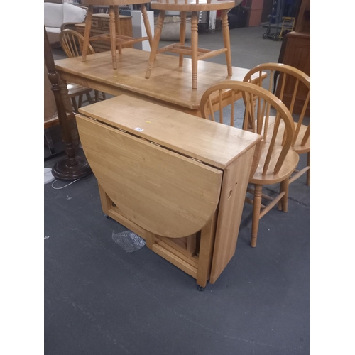 387 - A pine space saving drop leaf dining table with four chairs