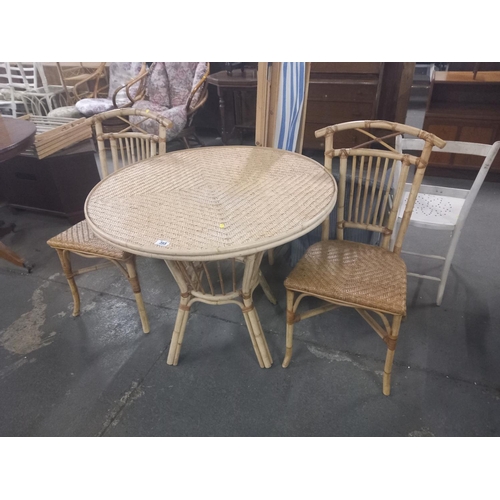 395 - A circular wicker and bamboo dining table together with two chairs