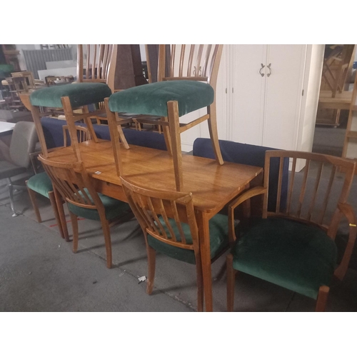 402 - A teak single drop leaf dining table with six chairs to include two carvers