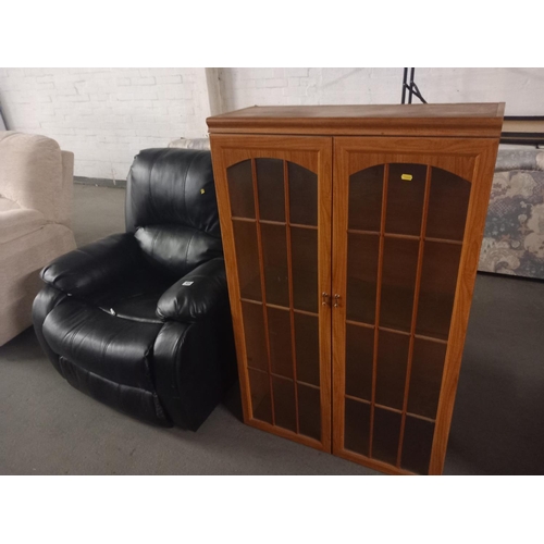 434 - A leatherette armchair together with a glass fronted bookcase