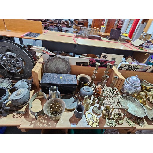 26 - A large quantity of metalware - brass jam pots, brass ornaments, film reels, silver plate, etc