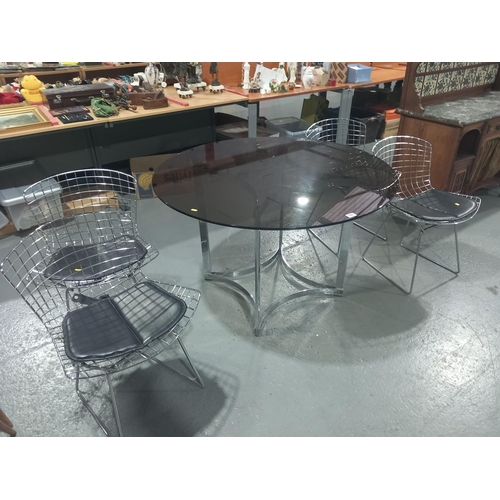 101 - A smoked glass circular topped dining table and four mid century style chairs