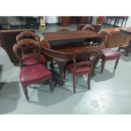 120 - A mahogany wind out extending dining table with one extra leaf, hand crank and six chairs