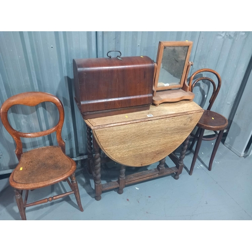 134 - An oak drop leaf dining table, two chairs, sewing macine and a dressing table mirror