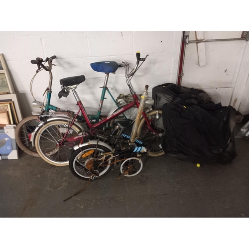 424 - 3 folding bicycles together with a Raleigh and Universal bicycle