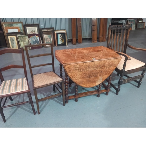 118 - An oak drop leaf dining table on barley twist supports, an oak armchair and two bedroom chairs