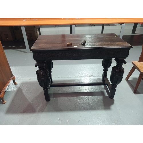 557 - An oak carved console table with two drawers