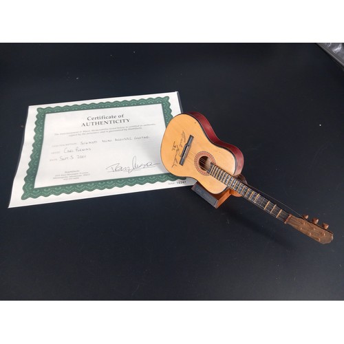 129 - A mini accoustic guitar with case signed by American singer, songwriter and guitarist 