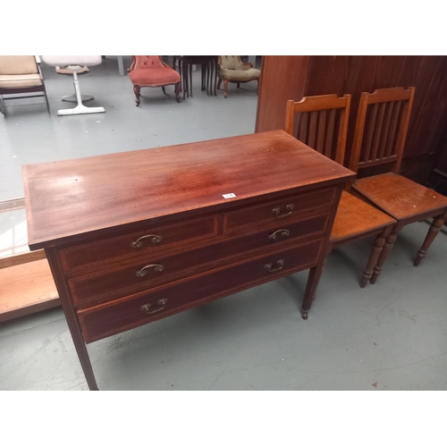 134 - A mahogany two over two chest of drawers together with two oak hall chairs