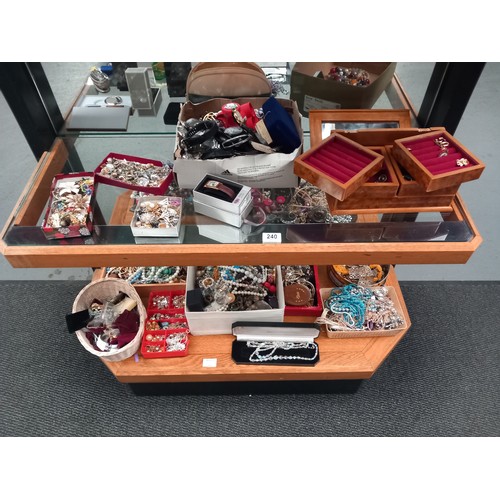 240 - A large quantity of costume jewellery displayed over two shelves