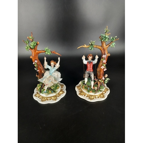 203 - A paire of ornate Capodimonte figurines - male and female on swings - both signed