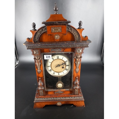 225 - An ornate antique mantle clock with key - appears to be working but not guaranteed