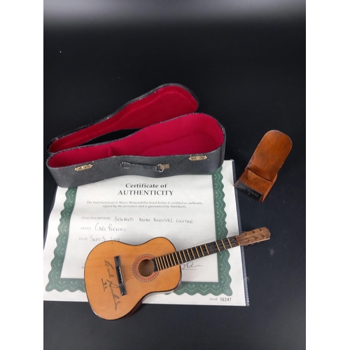 233 - A mini accoustic guitar with case signed by American singer, songwriter and guitarist 