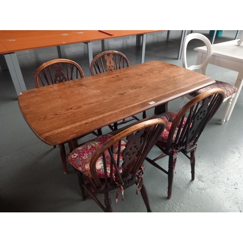 117 - An oak dining table with four wheelback chairs