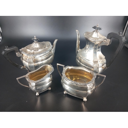 202 - A George V four piece hallmarked silver tea service having a gadrooned edge above reeded bonding wit... 