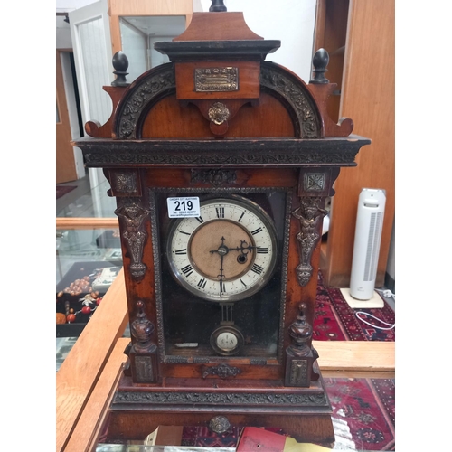 219 - An ornate antique mantle clock with key - appears to be working but not guaranteed