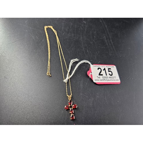 215 - A 9k gold and garnet cross pendant on a 9k gold chain