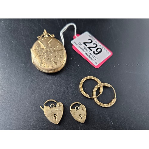 229 - A 9k gold large locket, a pair of 9k gold earrings and two 9k gold bracelet catches - combined weigh... 