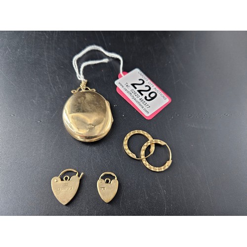 229 - A 9k gold large locket, a pair of 9k gold earrings and two 9k gold bracelet catches - combined weigh... 