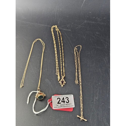 243 - A 9k gold stone watch fob on 9k gold chain, a 9k gold chain and a 9k gold pendant with garnet on 9k ... 