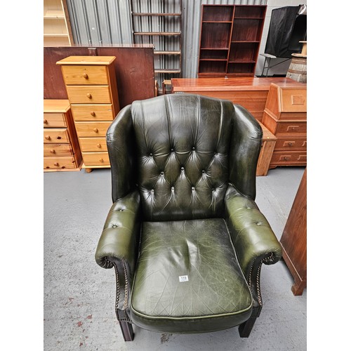 119 - A green leather Chesterfield style wingback armchair